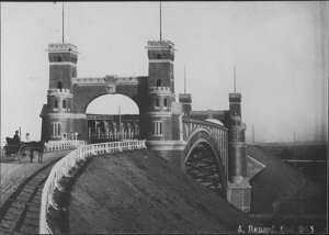 Levensauer Hochbrücke nach ihrer Erbauung (1895) Historisches Schwarz-Weiß-Bild: Ein Pferdefuhrwerk vor der Durchfahrt unter dem Brückenportal. Deutlich zu erkennen die beiden Ecktürme auf jedem Brückenkopf.